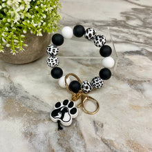 Load image into Gallery viewer, Silicone Bracelet Keychain - Black &amp; White Dog Paw
