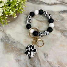 Load image into Gallery viewer, Silicone Bracelet Keychain - Black &amp; White Dog Paw
